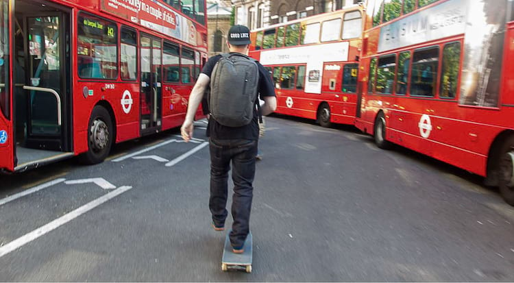 Roll Forever. Keith pushing through a street with red double decker buses <br><br> Photo: Broach